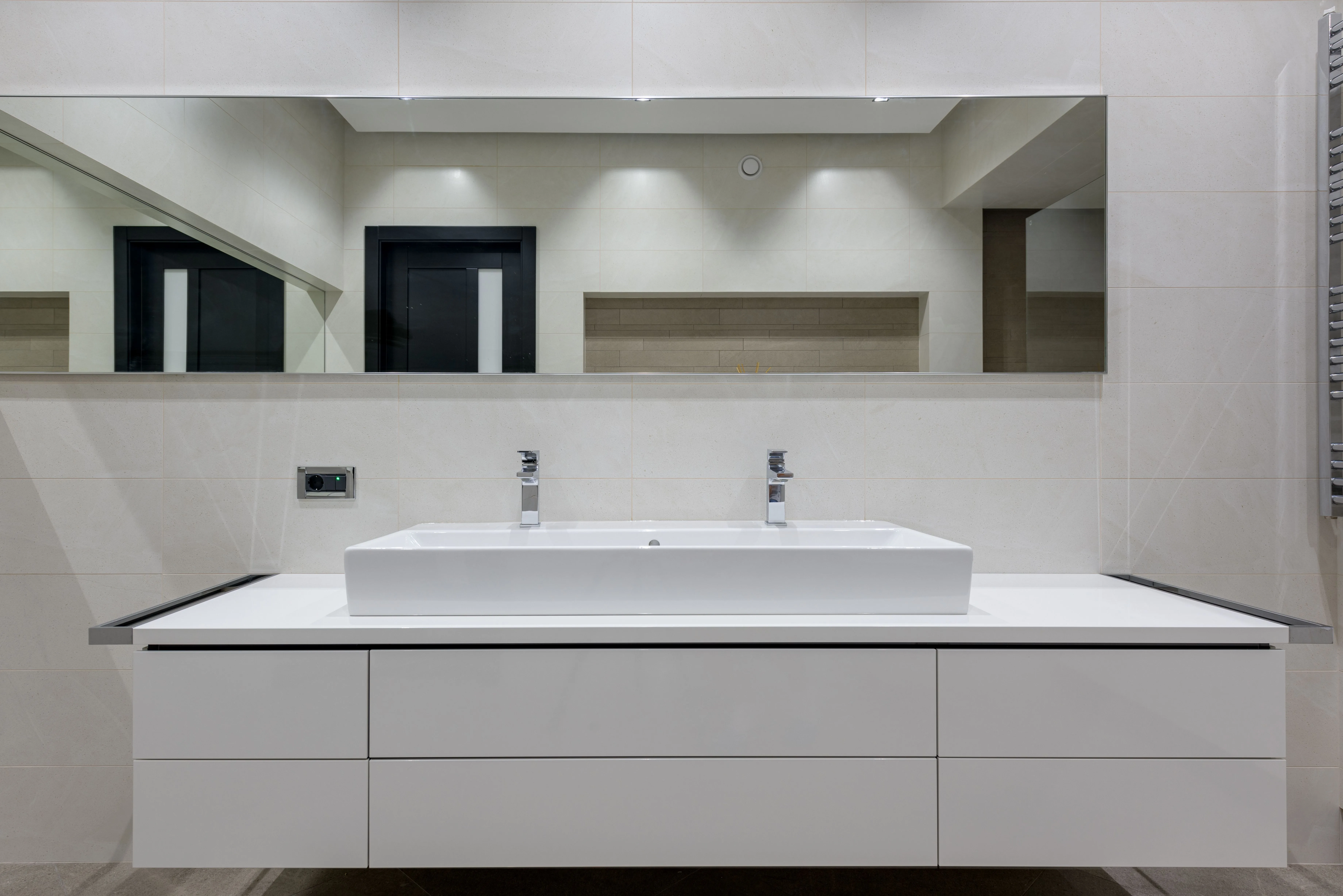 Stylish finished bathroom with a mirror over a white vanity table and vessel sink