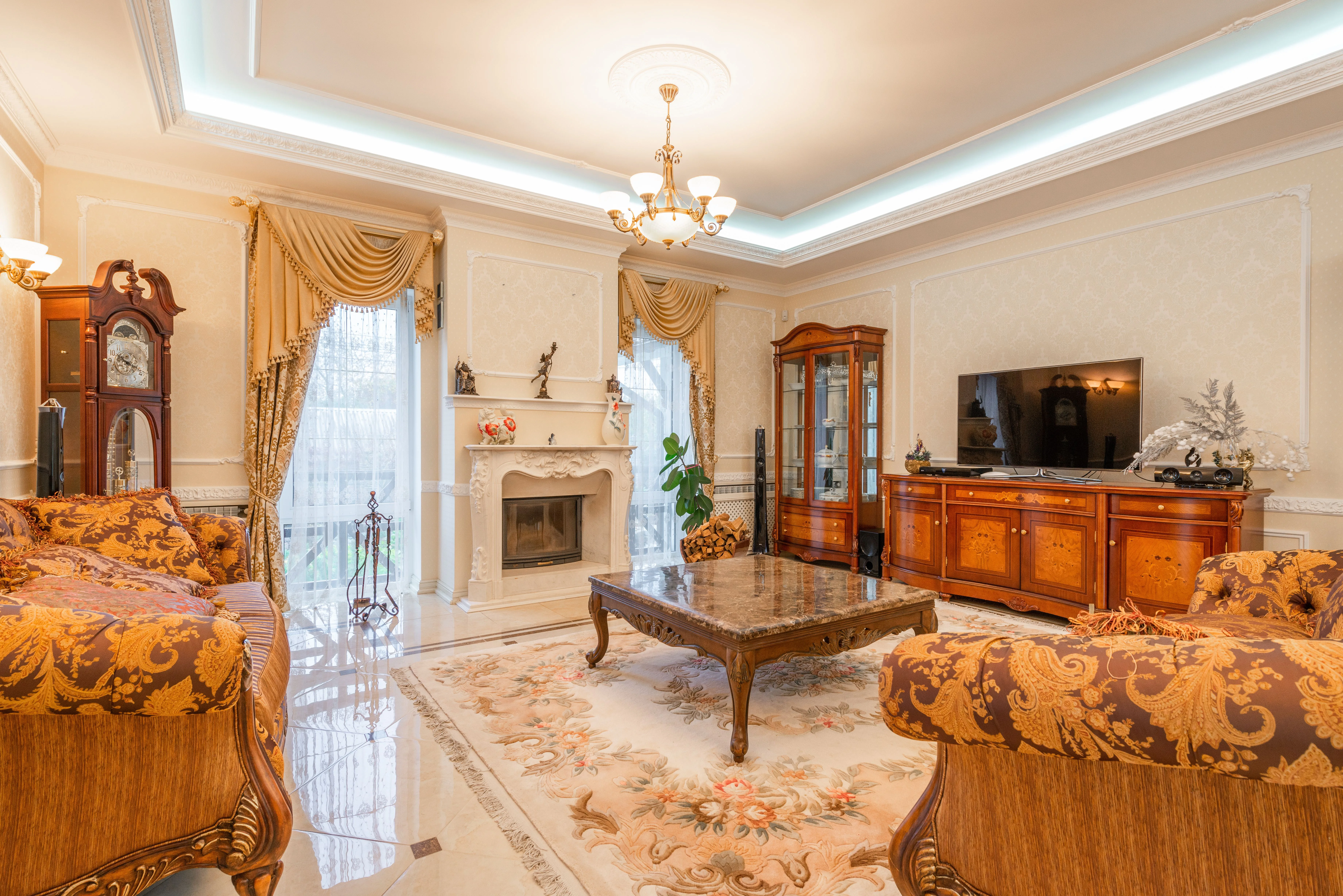 Luxurious living room with elegant furniture and decorative ceiling/wall molding visible, representative of a finished crown molding project
