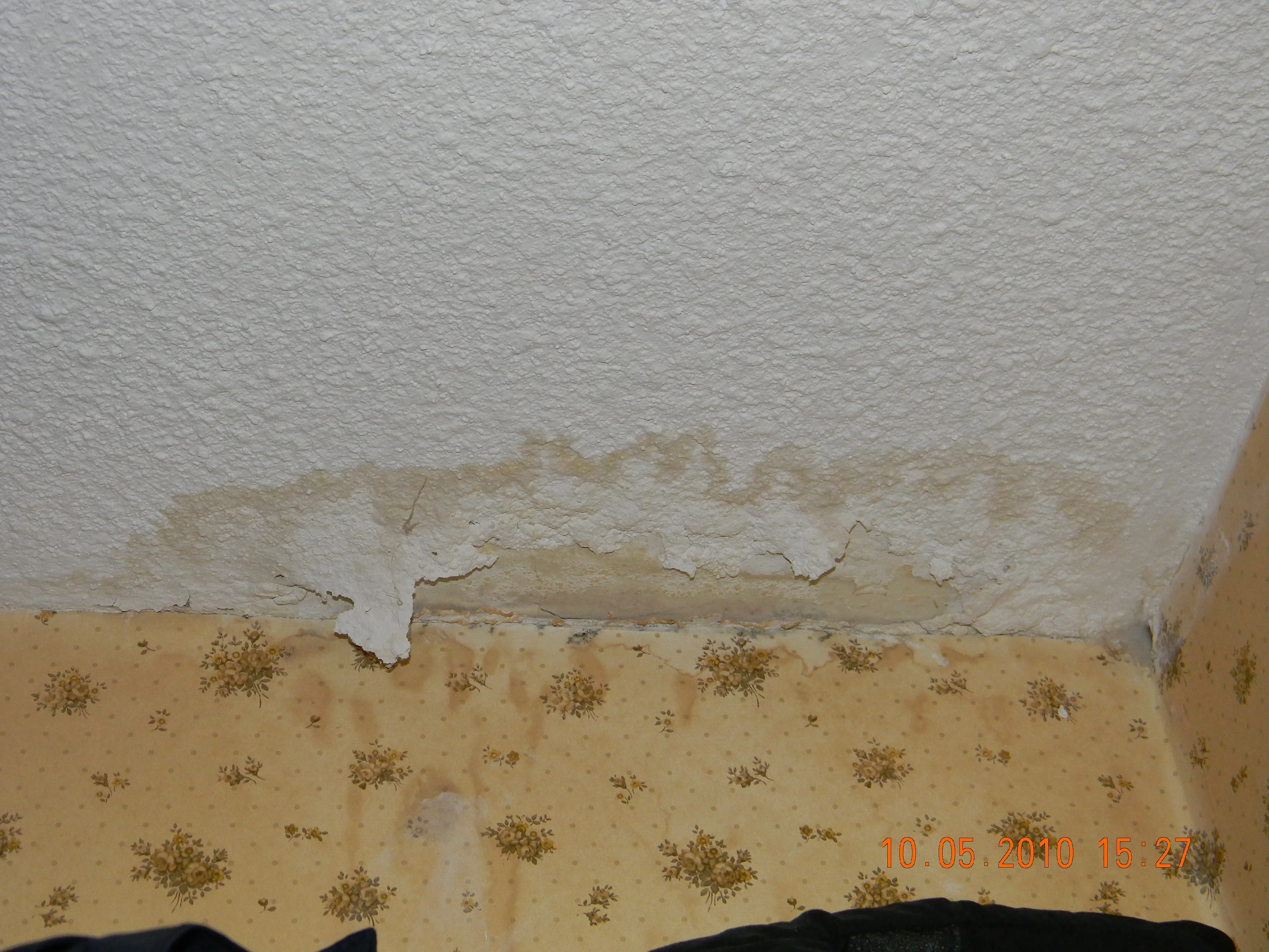 Close-up of a damaged drywall patch spot before repair, showing surface irregularity.