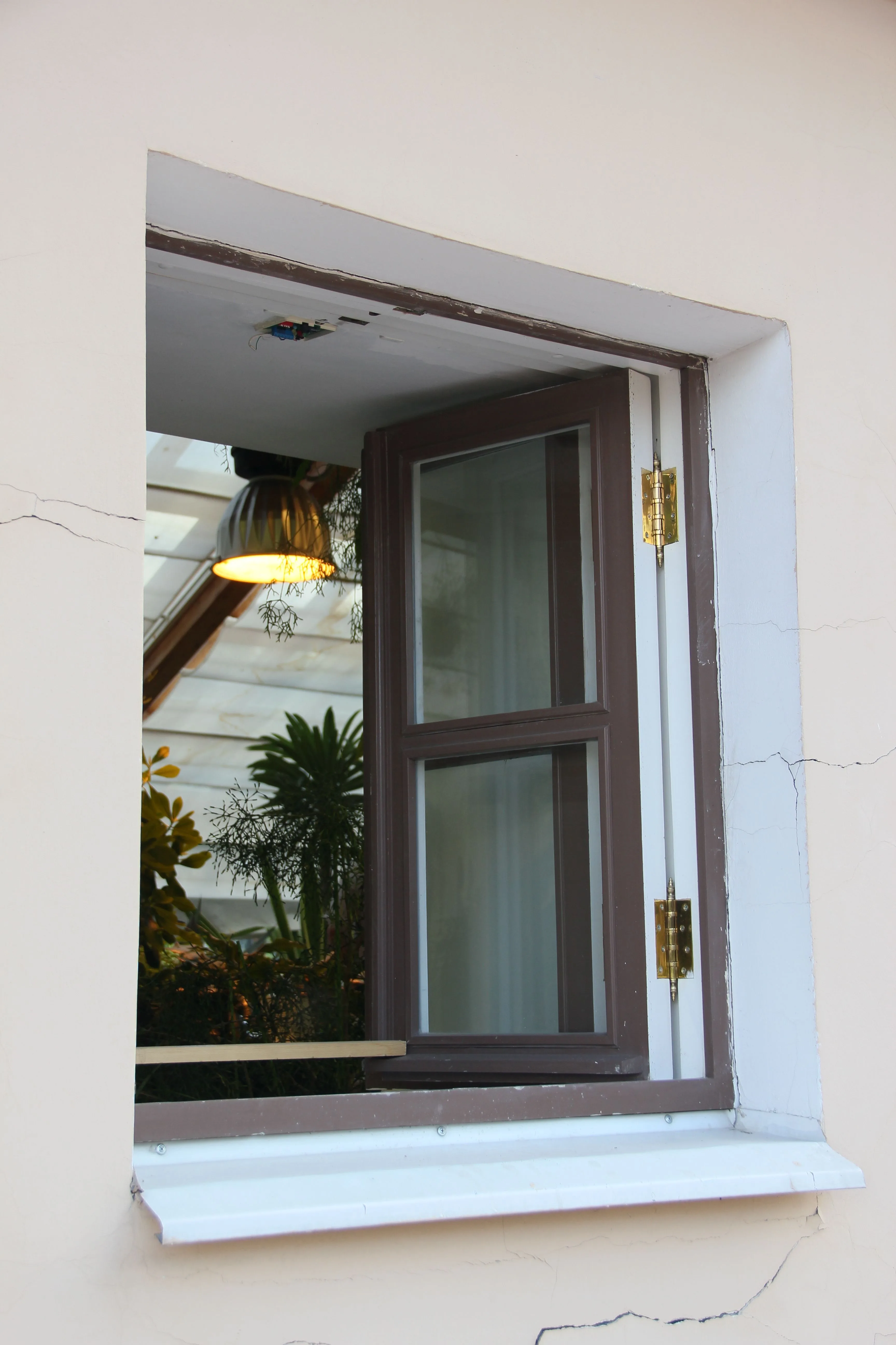 A wood-framed window successfully opened, showing the finished result of freeing a stuck sash